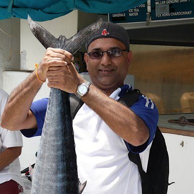 Big Island activities A man proudly holding up a large fish he caught on Big Island.