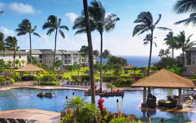 Tropical Kauai North Shore resort with a swimming pool, palm trees, and ocean view.