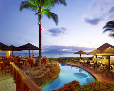 Maui Honua Kai Resort Tropical resort restaurant with poolside dining at sunset.