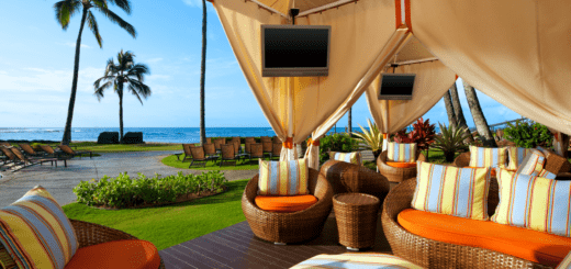 A patio with an umbrella and chairs on the ground